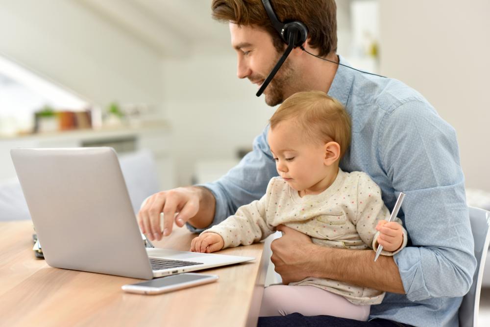 iSOS IT consultant man working from home with his baby 